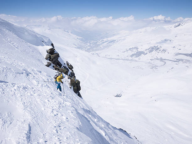 Female skier on steep slope above ski resort stock photo