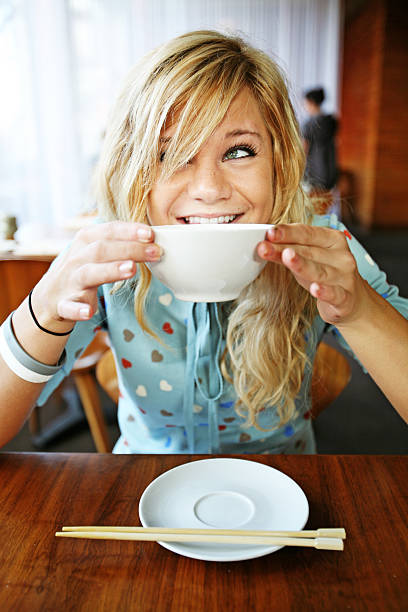 Uśmiechnięta dziewczynka jedzenie Zupa Miso – zdjęcie