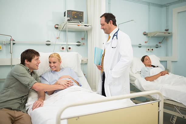 istock Obstetrician talking to a patient and her husband on bed 178487975
