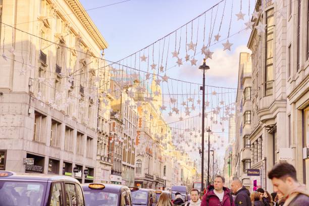 Oxford Circus, the junction of Regent Street and Oxford Street in central London, winter daytime pedestrians walking in and crossing the roadway London England UK - Christmas Season. captured at the junction of Regent Street and Oxford Street in London West End. Several people and pedestrians are walking in the street, and crossing the street. london fashion week stock pictures, royalty-free photos & images