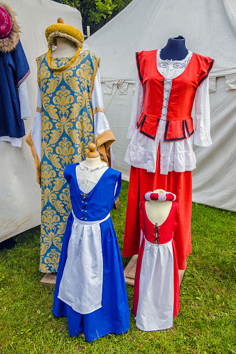Reconstruction from costumes from the Middle Ages in front of a tent in a public park