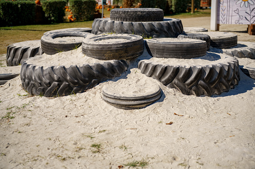 Old tires on a childrens playground sandpit