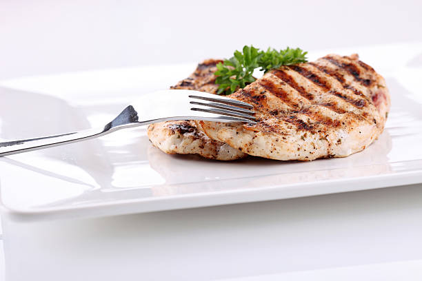 Grilled chicken breasts on a plate with fresh vegetables stock photo