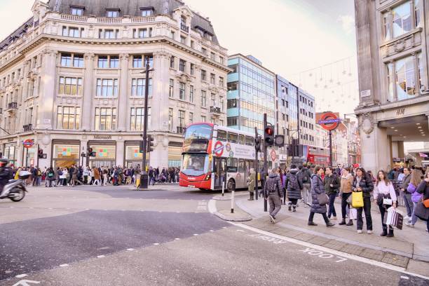 Oxford Circus, the junction of Regent Street and Oxford Street in central London, winter daytime pedestrians walking in and crossing the roadway London England UK - Christmas Season. captured at the junction of Regent Street and Oxford Street in London West End. Several people and pedestrians are walking in the street, and crossing the street. london fashion week stock pictures, royalty-free photos & images