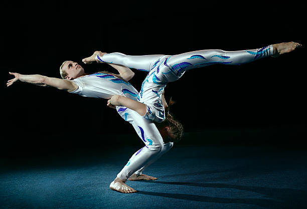 Male and female circus artists performing an acrobatic move