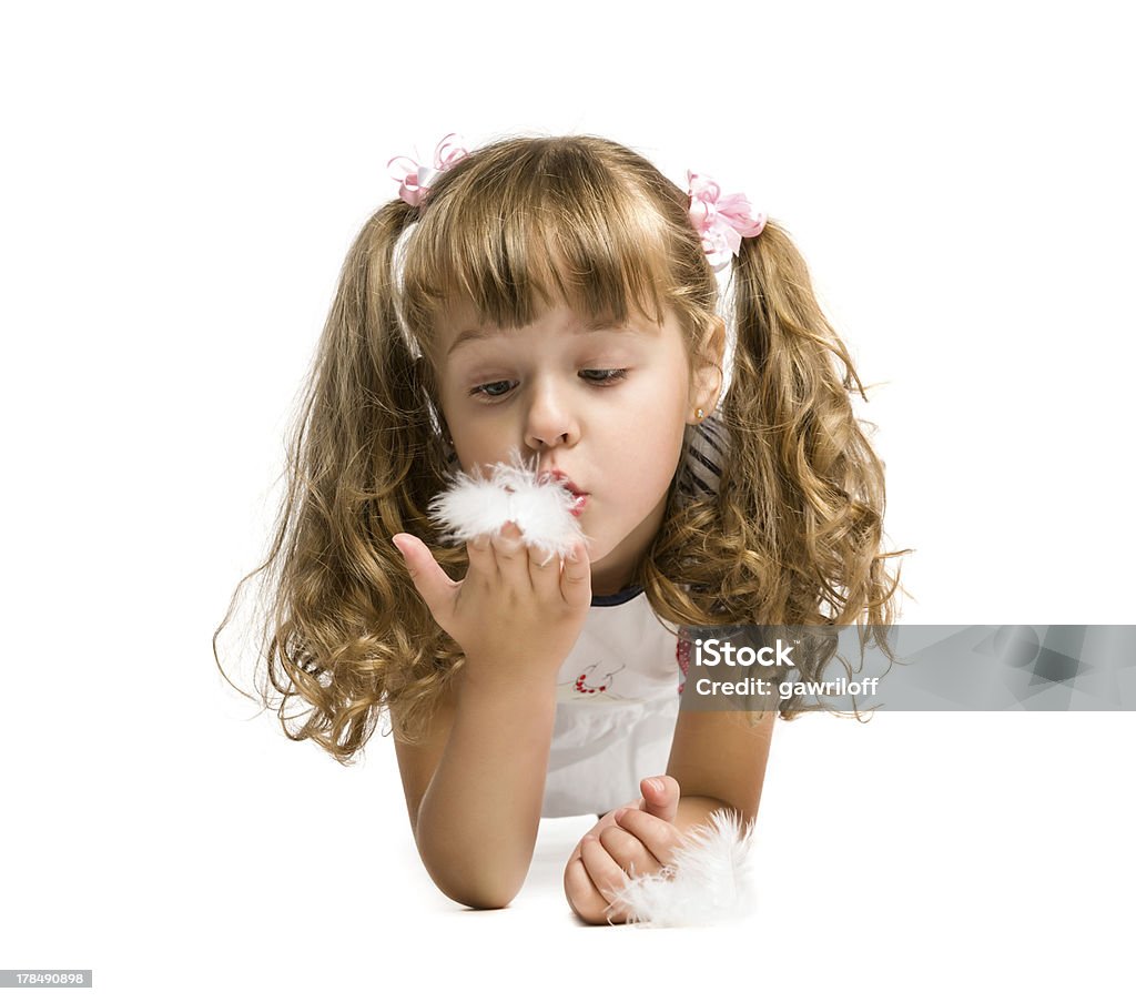 little girl blowing on a feather little girl blowing on a feather on a white background, isolated Activity Stock Photo