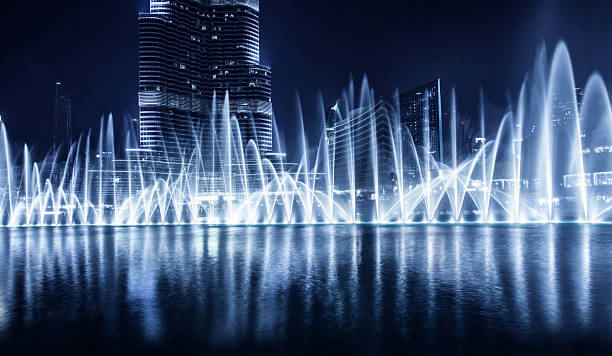 A distance night photograph of a fountain in Dubai Beautiful famous fountain in Dubai at night. khalifa stock pictures, royalty-free photos & images