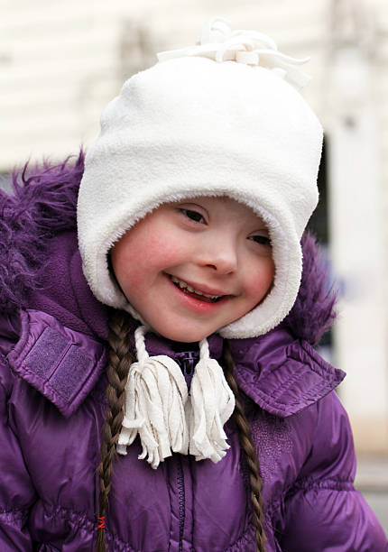 Close-up of cute little girl in a cap and a jacket in nature during an autumn day