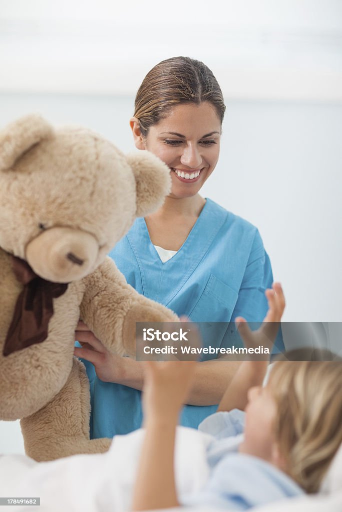 Lächelnd Krankenschwester mit Teddybär und ein Kind - Lizenzfrei Geschenk Stock-Foto