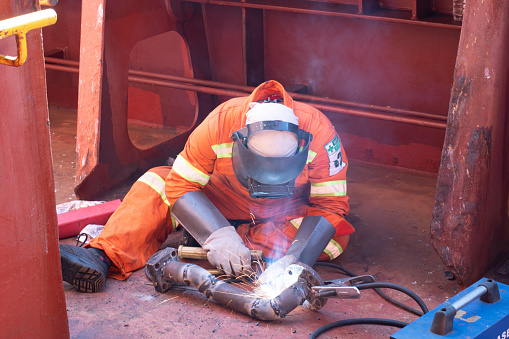 at sea, onboard ship -  november 5, 2023 : welder of ship fabricating a damage pipe line by welding