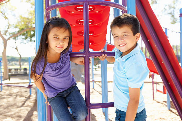 ragazzo e ragazza arrampicata nel parco di frame - playground schoolyard playful playing foto e immagini stock