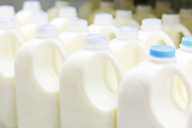 Plastic bottles of milk on factory production line Milk bottles in refrigerator bottling plant stock pictures, royalty-free photos & images