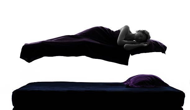 one woman sleeping in levitation on bed silhouette studio on white background