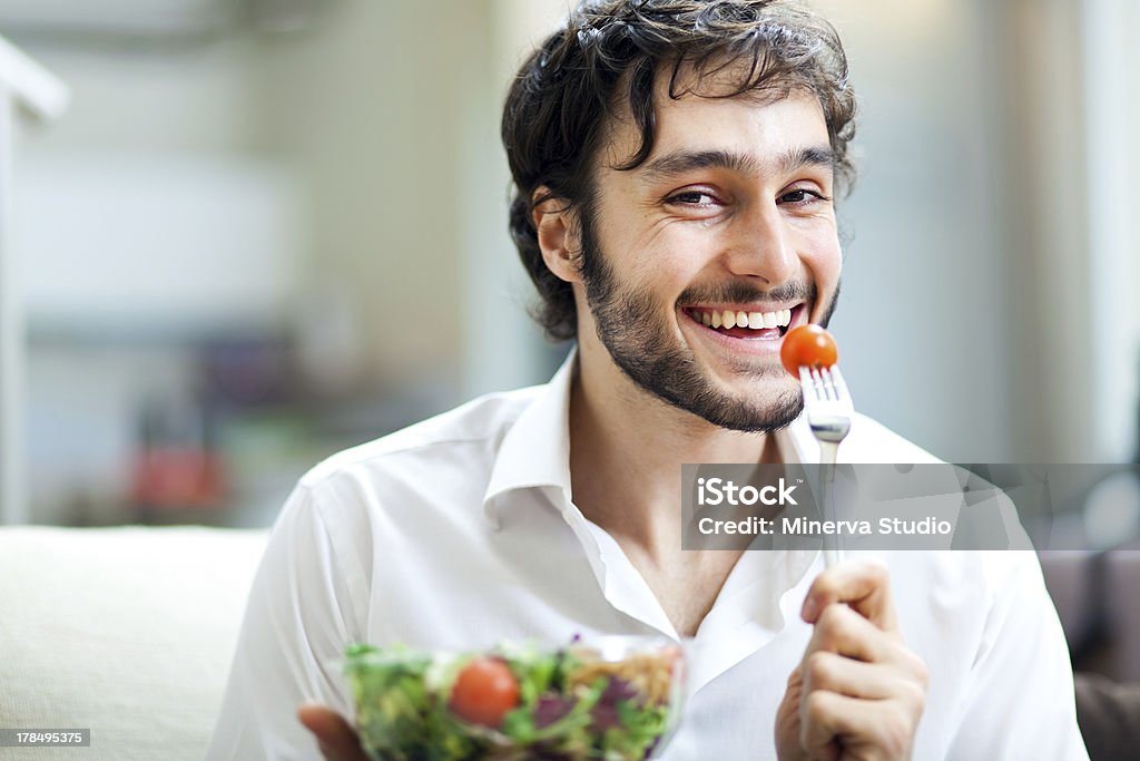 Healthy eating Man eating a healthy tomato Adult Stock Photo