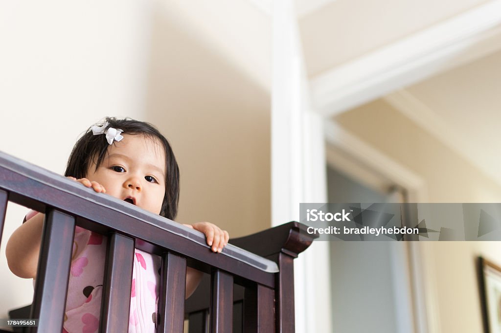 Cute bebê asiático Menina peering fora do seu berço - Royalty-free Bebé Foto de stock