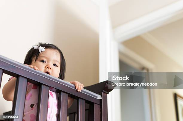 Cute Bebê Asiático Menina Peering Fora Do Seu Berço - Fotografias de stock e mais imagens de Bebé