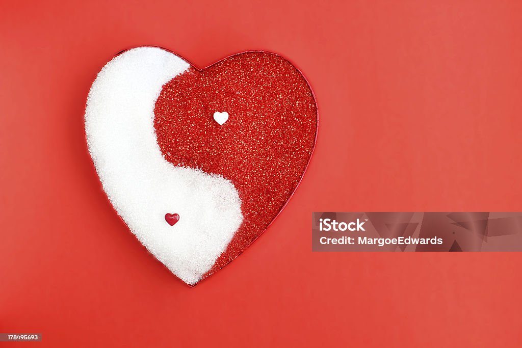 Yin Yang Concept photo in the shape of a heart showing the balance of male and female for Valentine's day on red background Yin Yang Symbol Stock Photo