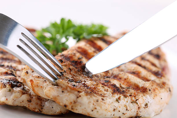 Grilled chicken breasts on a plate with fresh vegetables stock photo