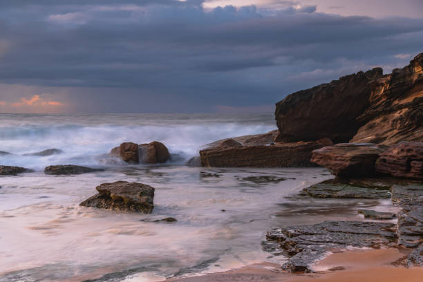 istock Sunrise seascape with low clouds and waves 1784964047