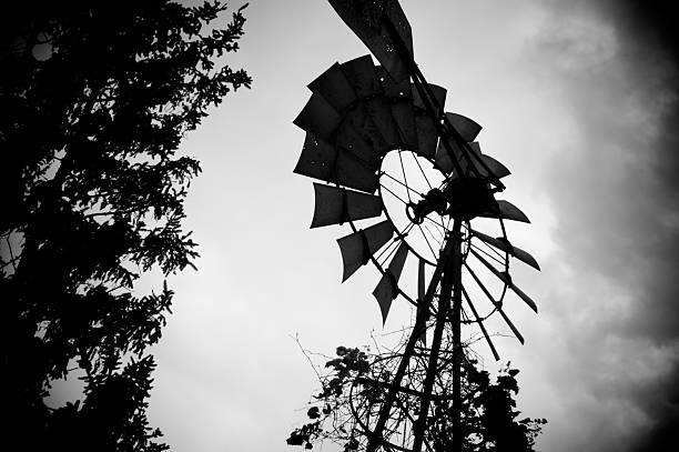 Moody windmill image against a cloudy sky. stock photo