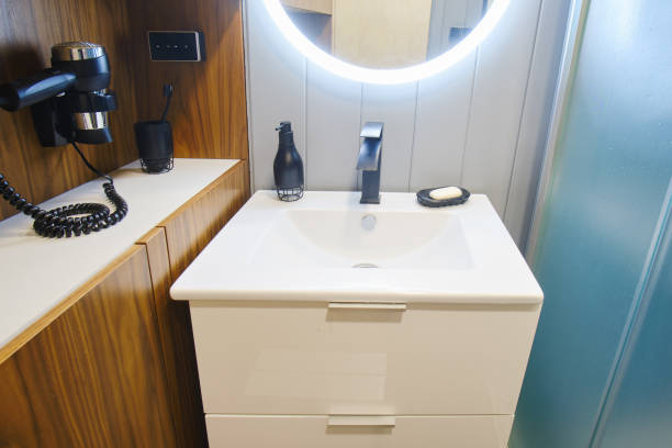 istock The compact bathroom features a glass shower cabin and a white cabinet. Round illuminated mirror over a white sink in a small bathroom 1784972620