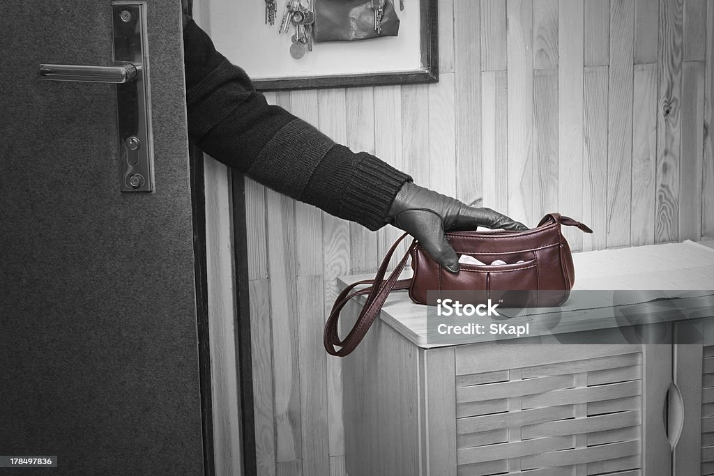 Burglary Thief breaking in doors and stealing a handbag. Stealing - Crime Stock Photo