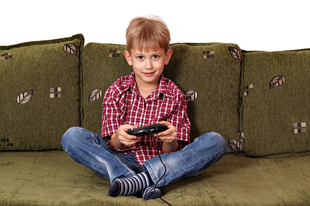 istock boy sitting on bed and play video game 178498860