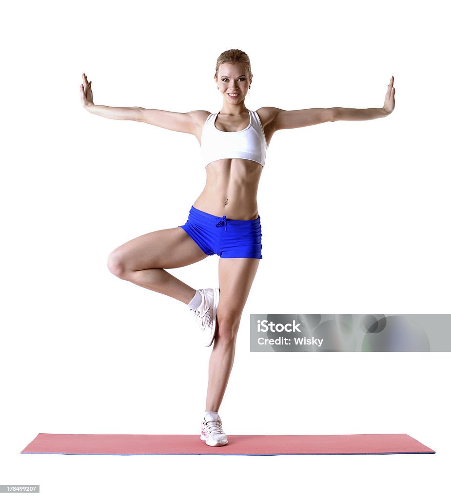 Attractive blonde posing on mat in studio Attractive blonde posing on mat in studio, isolated over white background Active Lifestyle Stock Photo