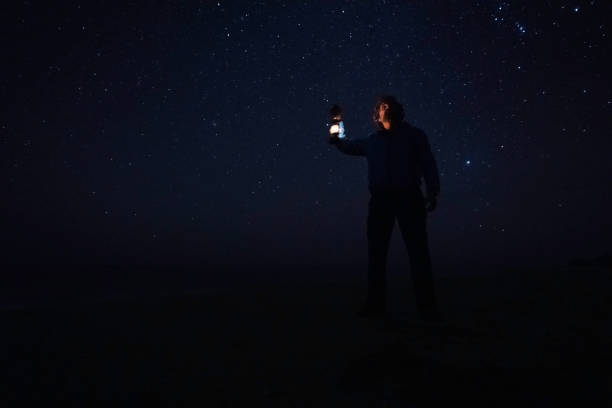 istock People and nature. Man stargazing at seaside at night. copy space 1784997030