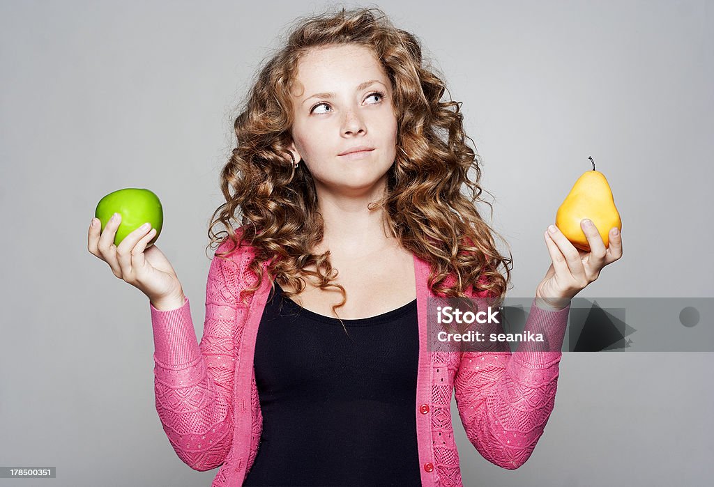 Junge Frau hält einen Apfel und eine Birne - Lizenzfrei Apfel Stock-Foto