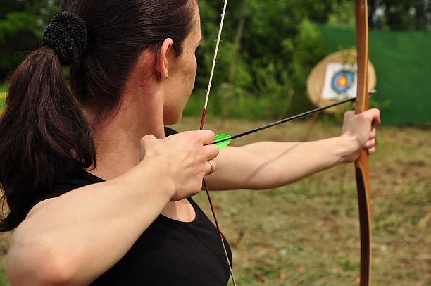 istock Woman aiming her bow and arrow at a target 178500945