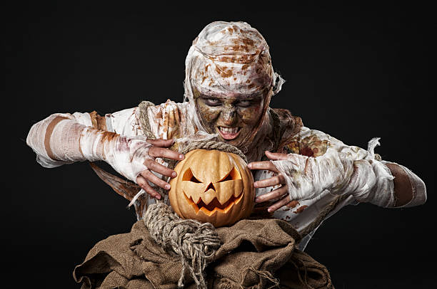 istock scary mummy holding the pumpkin 178501932