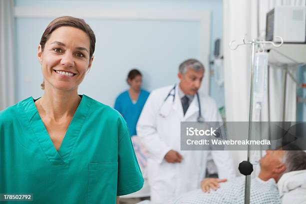 Sonriente Enfermera Pie En Un Hospital Habitación Foto de stock y más banco de imágenes de 20 a 29 años - 20 a 29 años, 30-39 años, 50-59 años