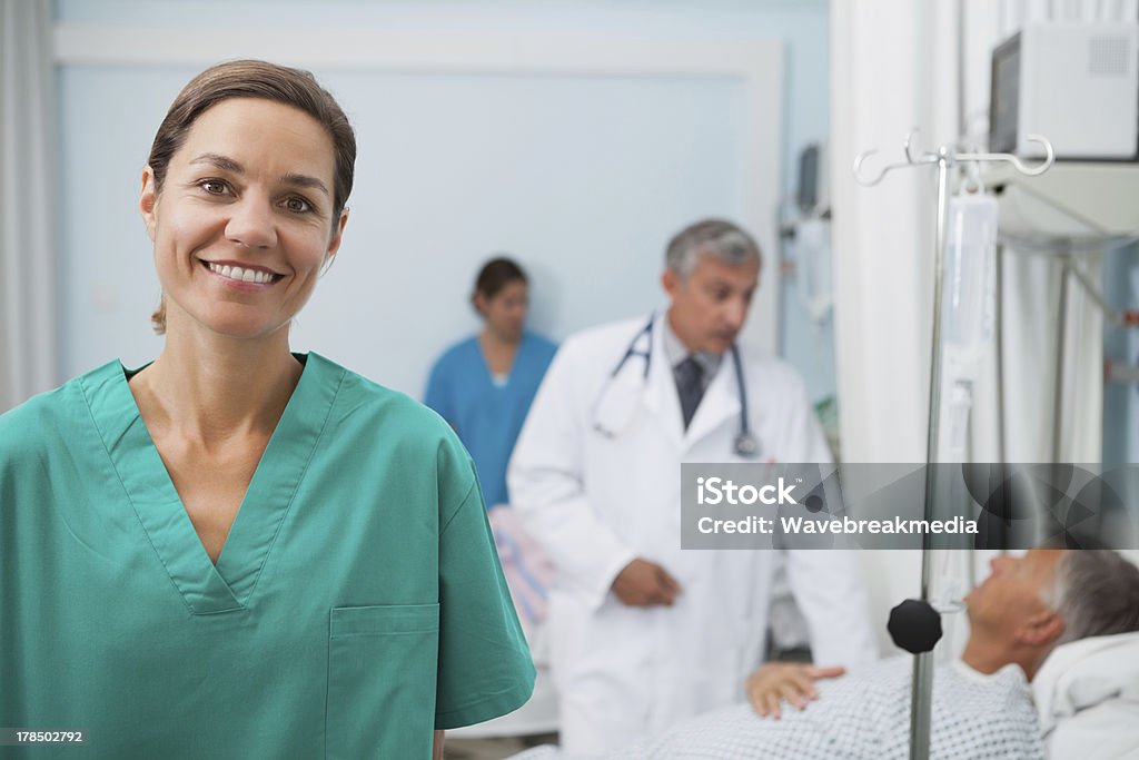 Enfermeira sorridente em pé em um quarto de hospital - Foto de stock de 20 Anos royalty-free