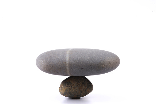 A picture of a rock standing together with a balanced weight
