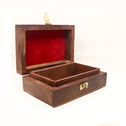 a brown, handcrafted wooden gift box for storing jewellery and money with red velvet lining, empty and open isolated