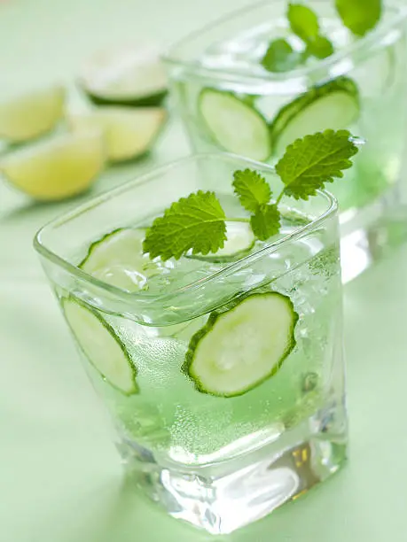 Cold fresh lemonade with cucumber and ice, selective focus