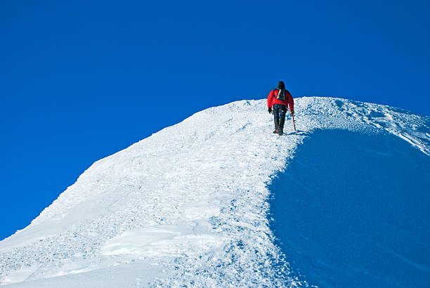 Lone male mountain climber on summit stock photo