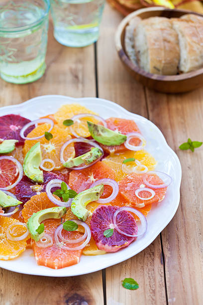 Ensalada de frutas cítricas y aguacate y cebolla. Listo para comer. - foto de stock