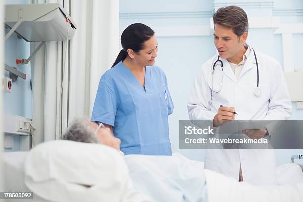 Médico E Enfermeira Falar Com Um Paciente - Fotografias de stock e mais imagens de 30-39 Anos - 30-39 Anos, 70 anos, Adulto