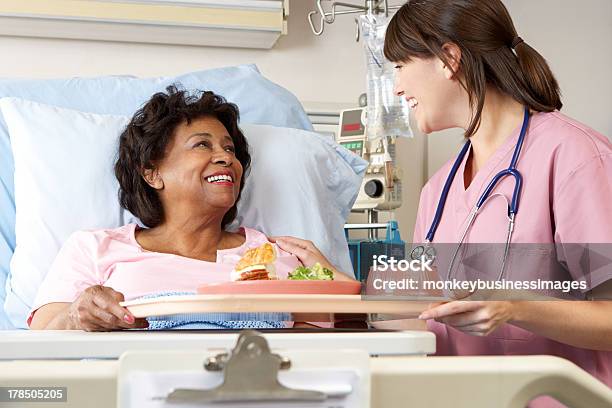 Nurse Serving Senior Patient Meal In Hospital Bed Stock Photo - Download Image Now - Hospital, Food, Patient