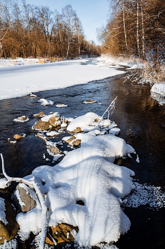 Open water snow frost. ice on the river froze. cold season. mountain stream stones. Thaw spring forest. nature silence