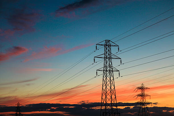 few electricity cable communication towers at sunset, feel the power. stock photo