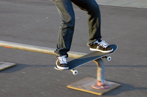 Skateboard and sneakers teenager rail slide stock photo