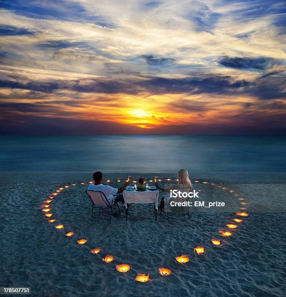 Young Couple Share A Romantic Dinner On The Beach Stock Photo - Download Image Now - Beach, Honeymoon, Romance