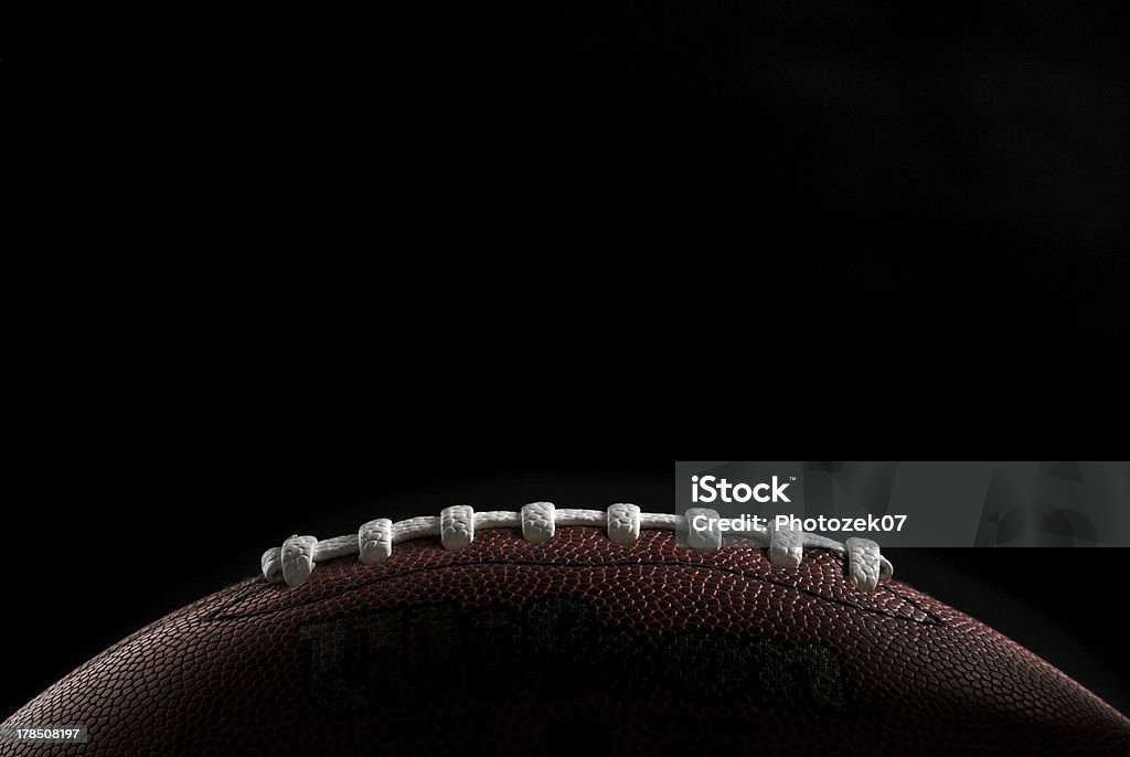 American football Close up of a football over black background American Football - Sport Stock Photo