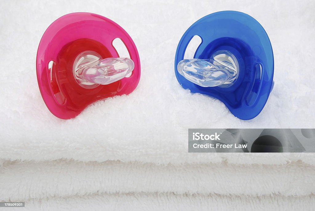 Rojo y azul pacifiers en toalla blanca - Foto de stock de Azul libre de derechos