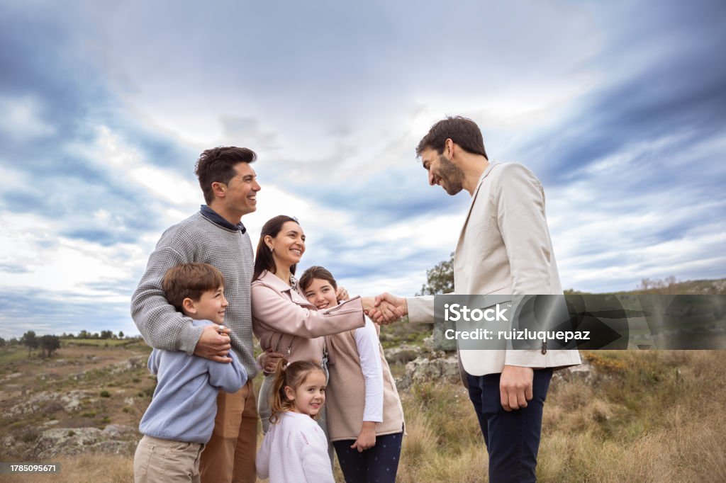 Real estate agent showing family allotment to build their new home Real estate agent showing family allotment to build their new home - Buenos Aires - Argentina 10-11 Years Stock Photo