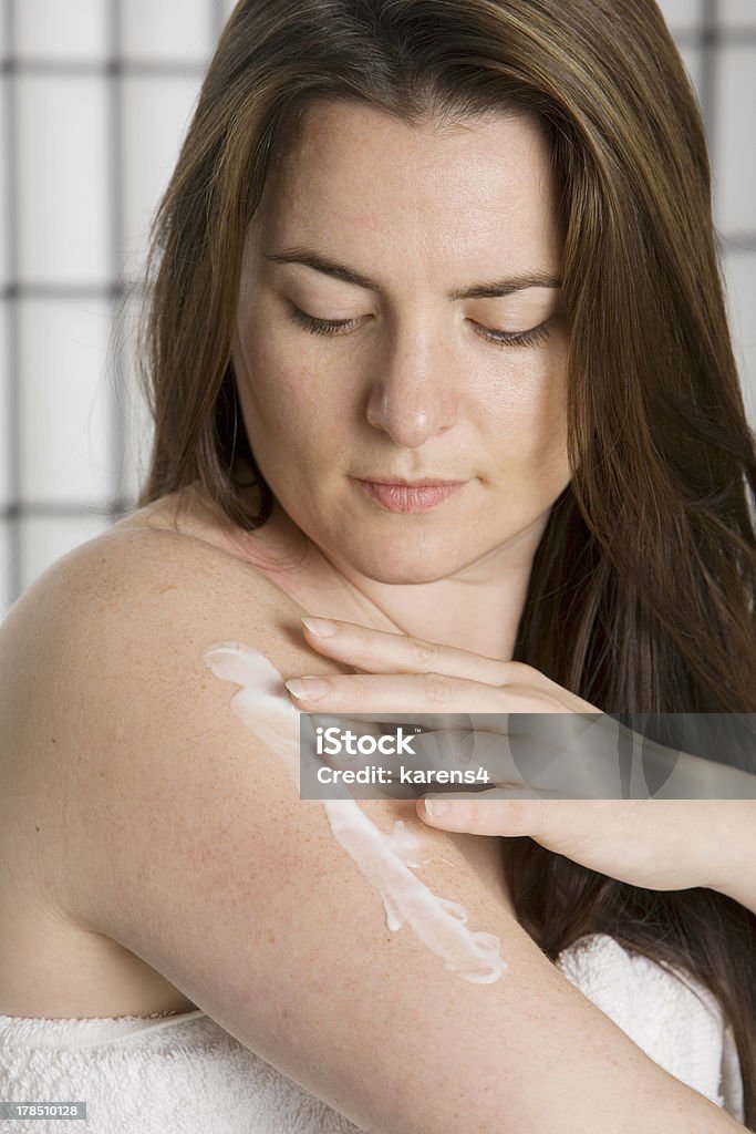 Jolie jeune femme sur une lotion hydratante puting - Photo de Adulte libre de droits