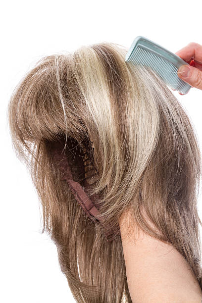 istock Woman combing her wig on white 178510255